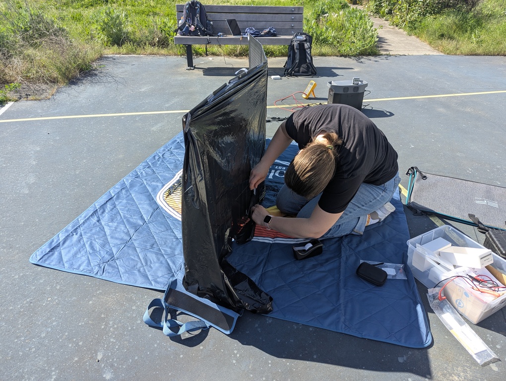 Amanda taping the garbage bag to block the bifacial side